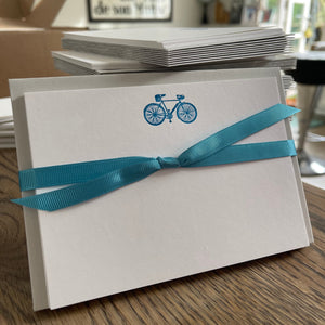 Drop handled racer bicycle printed in neon blue ink on a white A6 size card and tied with matching blue grosgrain ribbon